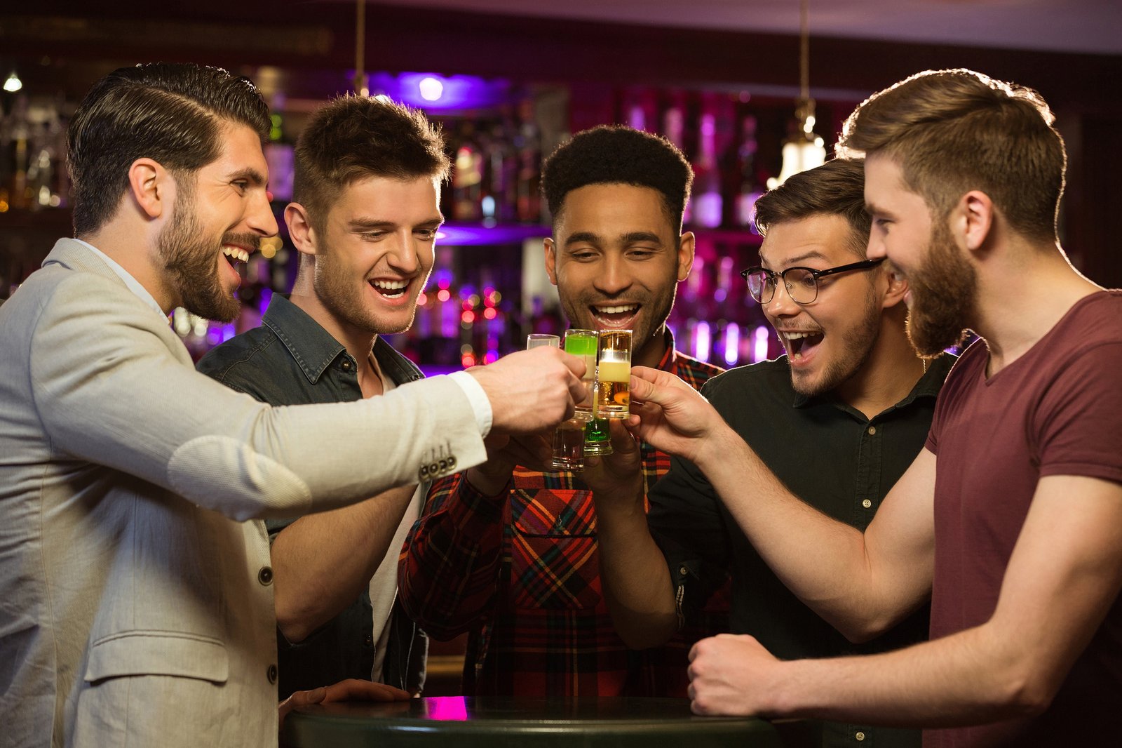 Happy male friends drinking beer and clinking glasses