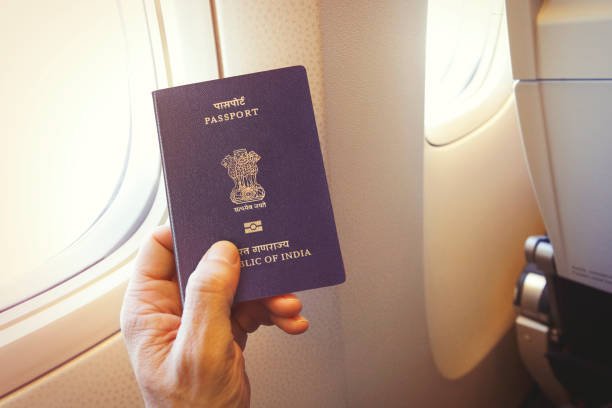 Passenger holding Indian passport on the airplane